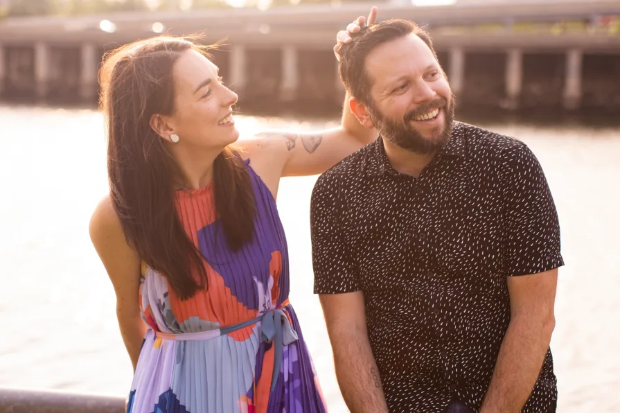 Two engaged folks smiling in Schuylkill River Park.