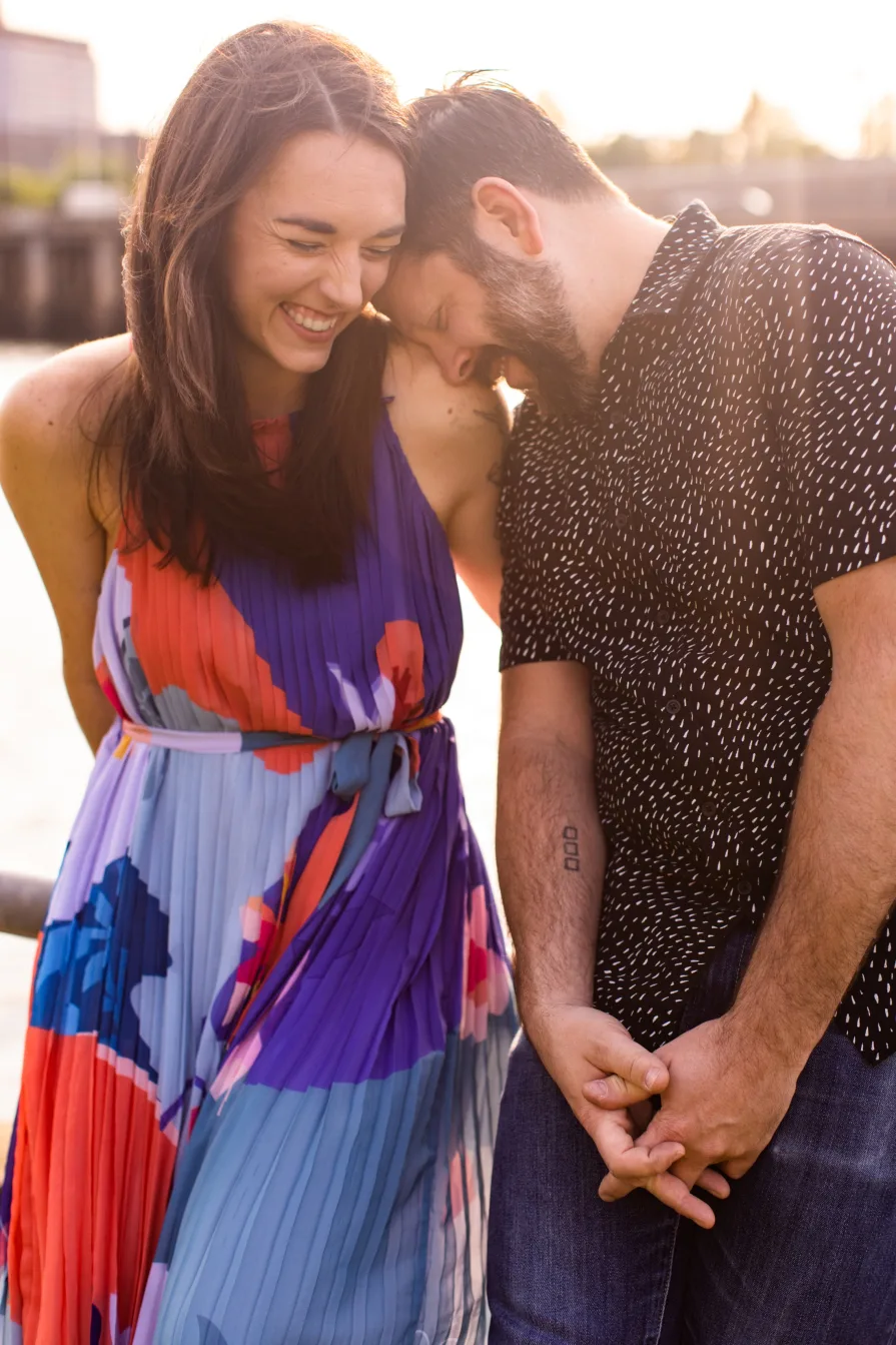 Two engaged folks smiling in Schuylkill River Park.