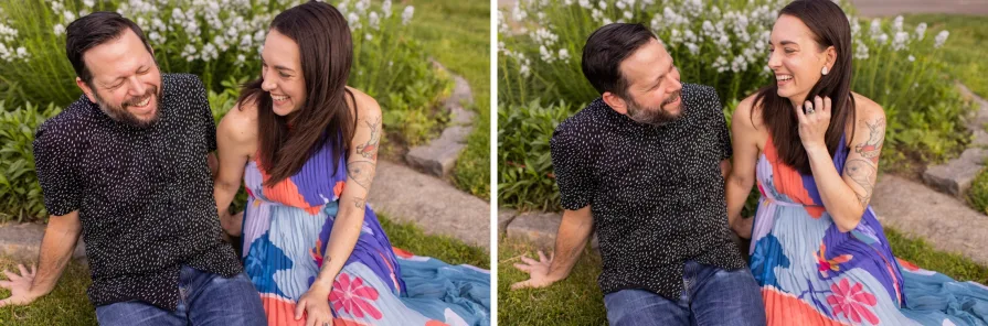 An engaged couple kissing while sitting on the grass in Schuylkill River Park.
