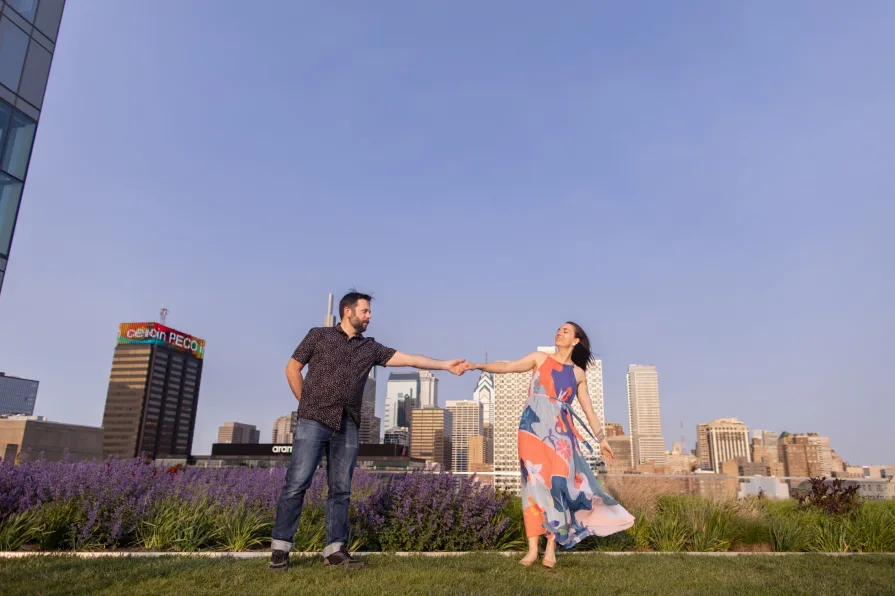 Engagement photos of a couple dancing on the Cira Green rooftop garden in Philadelphia.