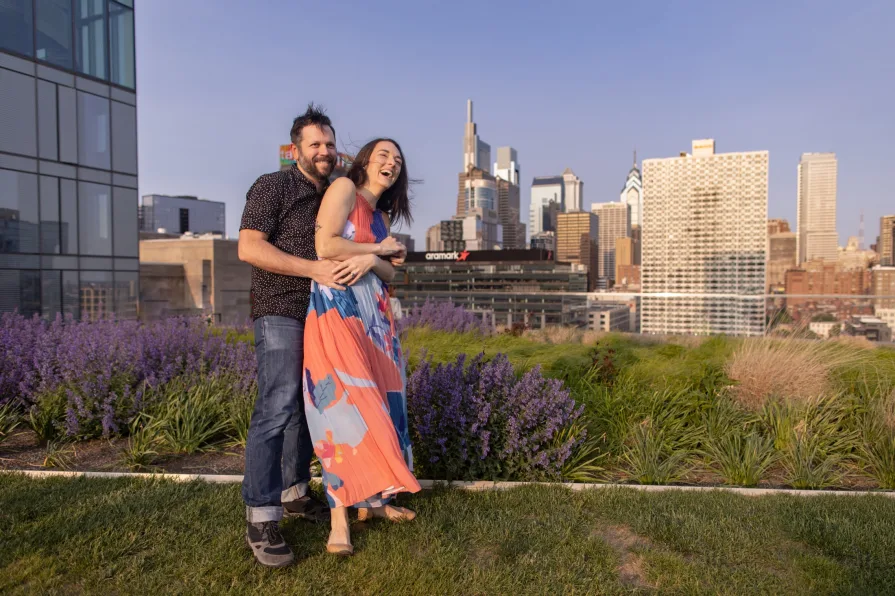 Engagement photos of a couple dancing on the Cira Green rooftop garden in Philadelphia.