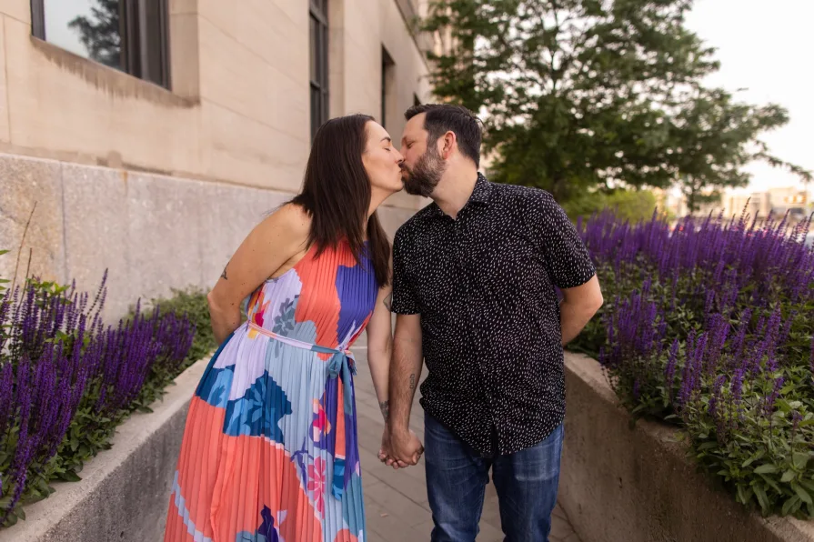 A couple standing in a floral-lined path near 30th Street Station.