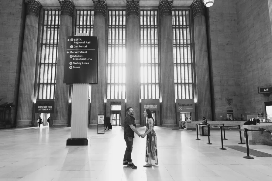 Black and white engagement photos inside 30th Street Station in Philadelphia.