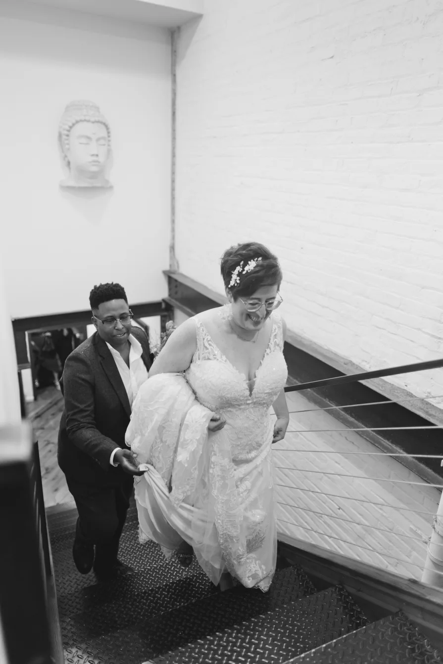 A queer, biracial couple walking up the stairs of Power Plant Productions.