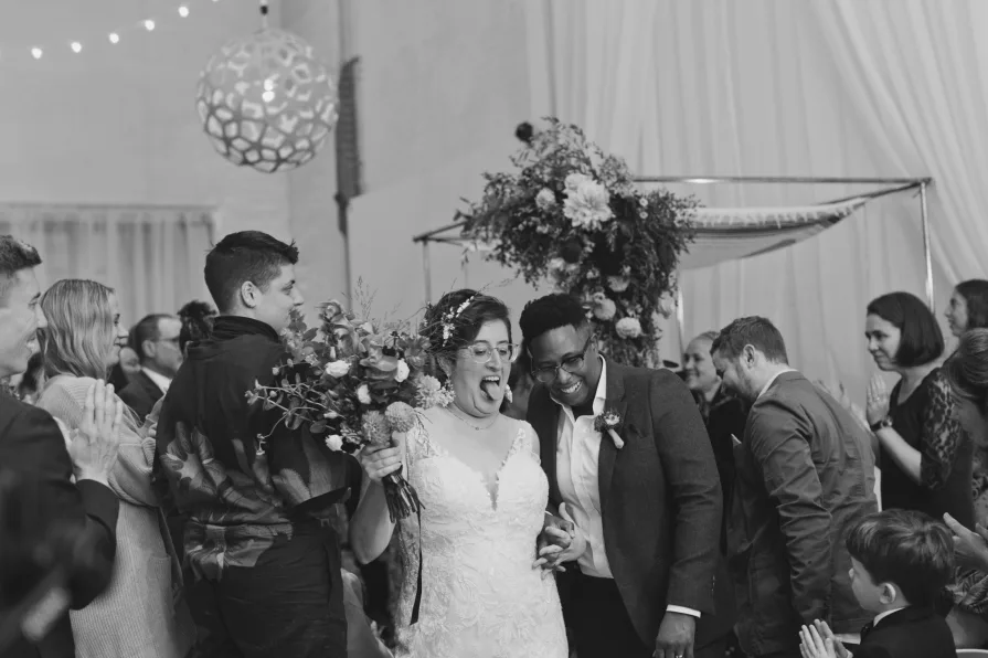 A black and white photo of the happy couple during their recessional.