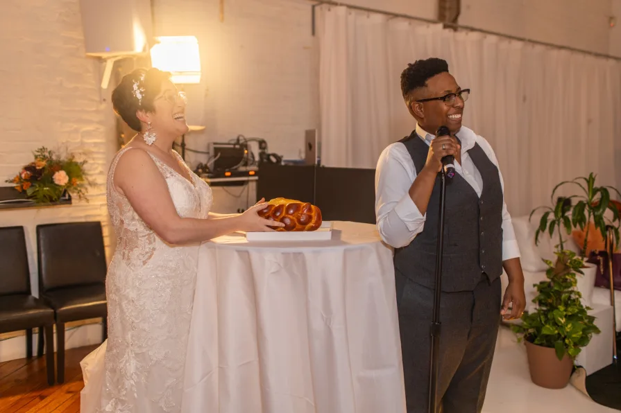 The marriers toast to their guests while blessing the ceremonial challah.