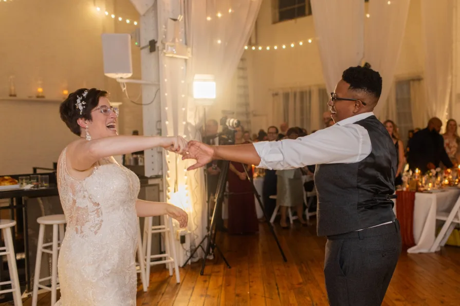 A queer, biracial couple during their first dance at an Old City wedding at Power Plant.