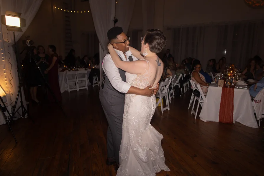 A queer, biracial couple dancing at a reception during an Old City wedding at Power Plant.