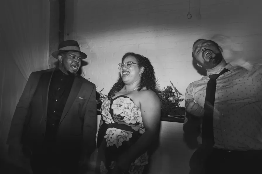 Guests dance from the sidelines in a black and white.