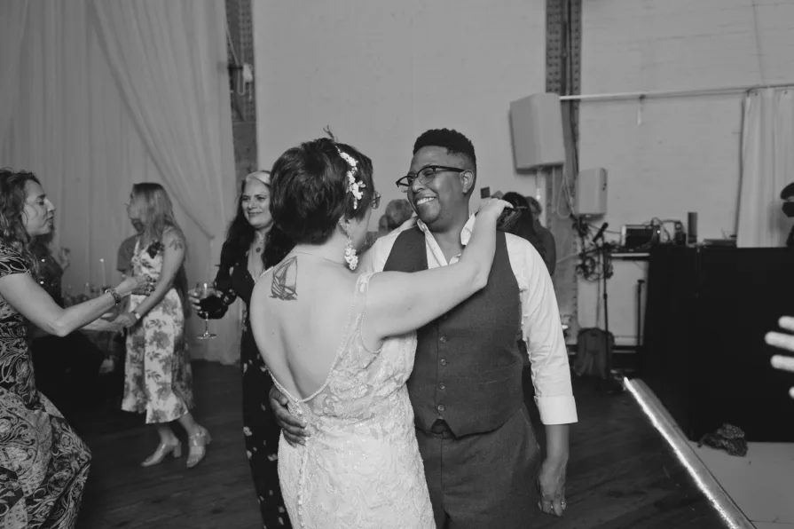 A queer, biracial couple dancing at a reception during an Old City wedding at Power Plant.