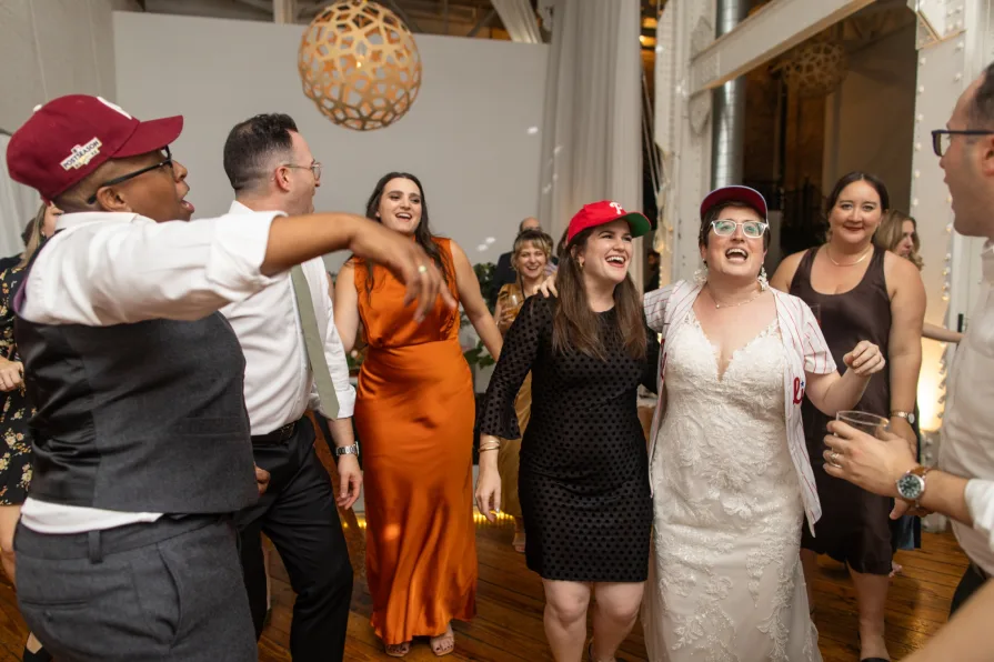 Wedding guests with Phillies gear dance to "Dancing On My Own" at a reception.