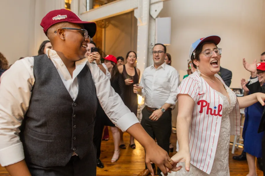 Wedding guests with Phillies gear dance to "Dancing On My Own" at a reception.