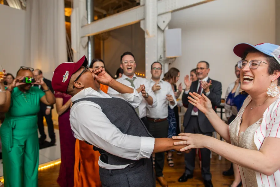 Wedding guests with Phillies gear dance to "Dancing On My Own" at a reception.