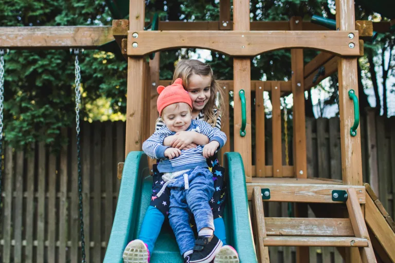 kids going down a slide in the fall