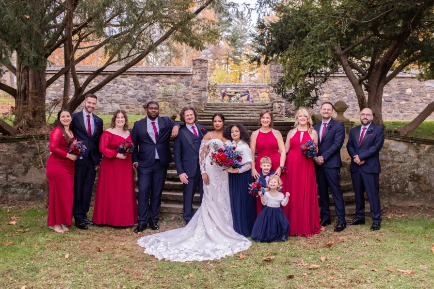 A wedding party in front of the stone stairs at Parque at Ridley Creek State Park.