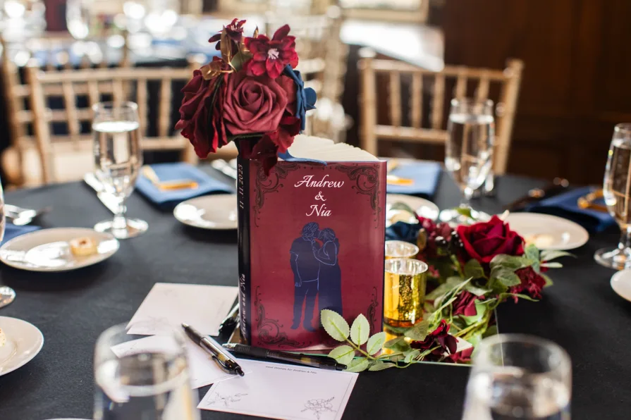 Wedding details at a reception with a personalized book with the couple's name.