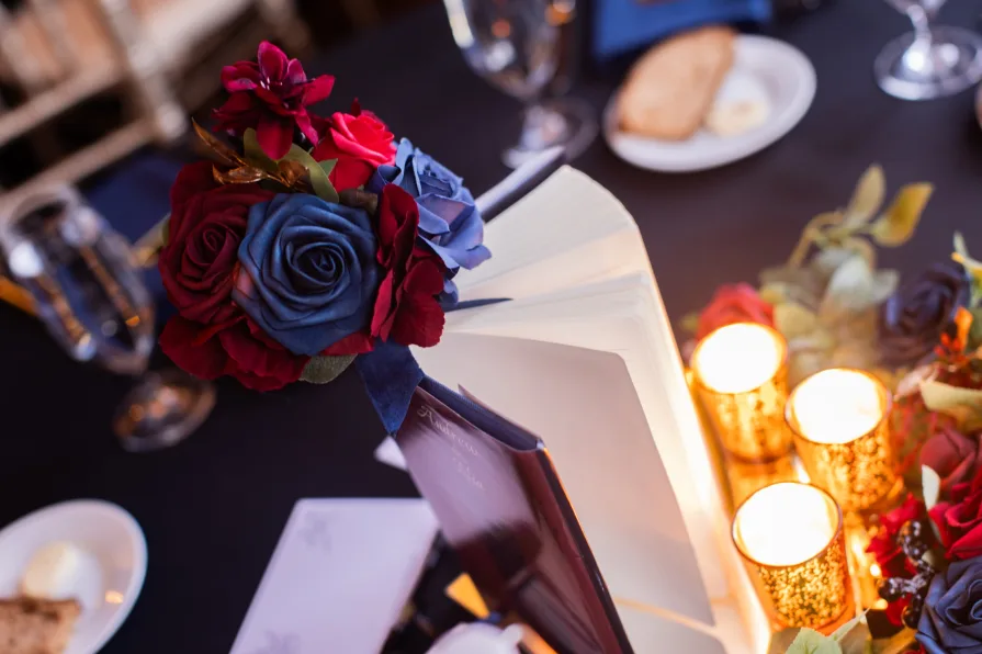 Wedding details at a reception with a personalized book with the couple's name.