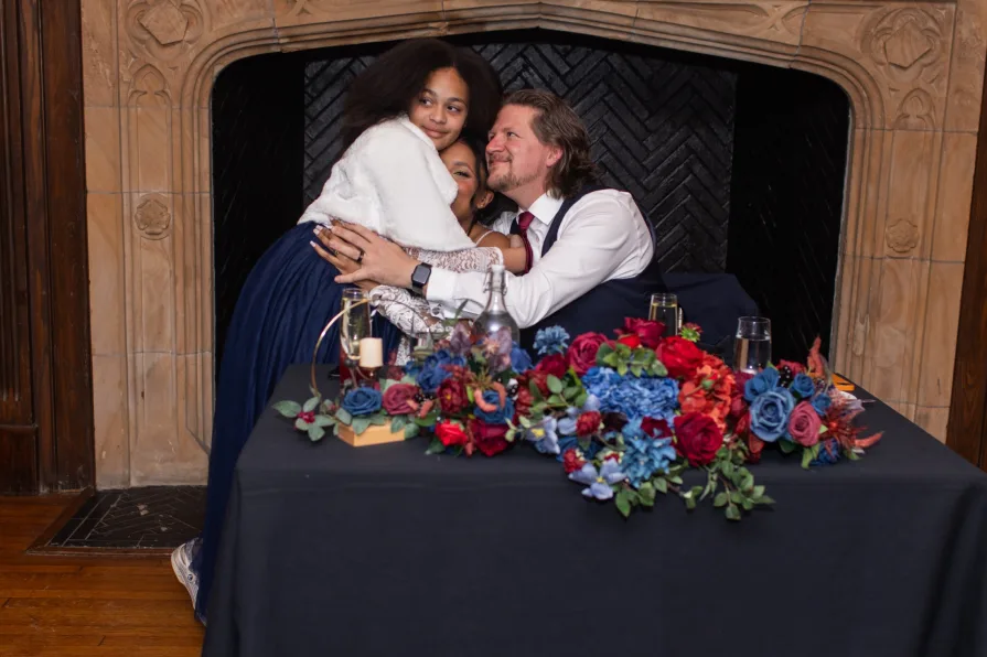 A smiling, hugging photo of family at a wedding.