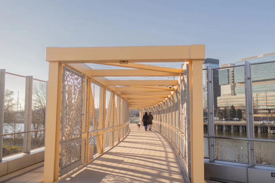 A couple walking on a bridge near the Schuylkill River.
