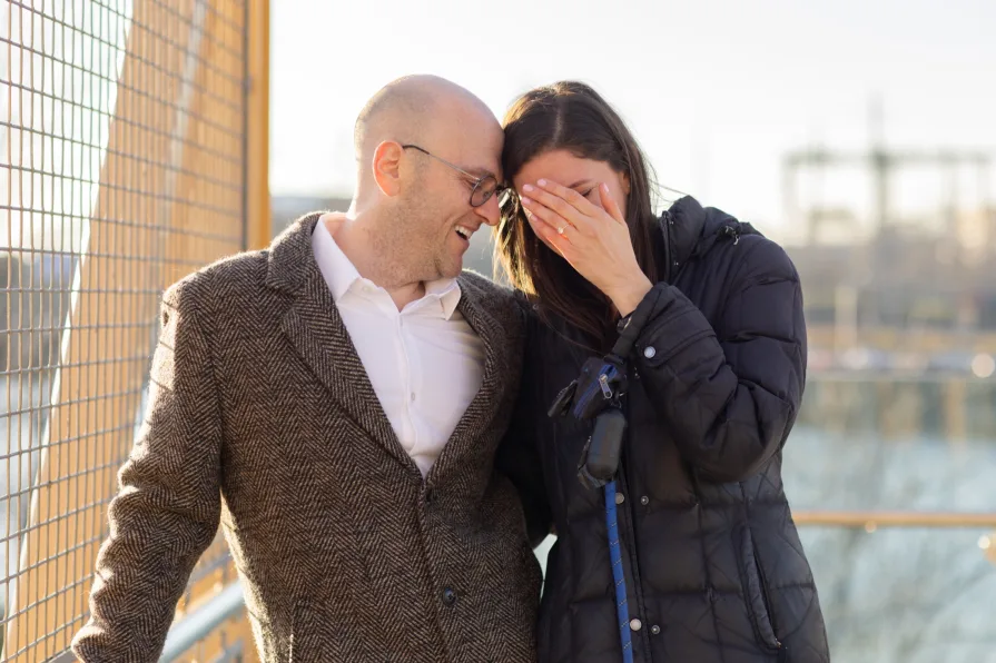 A couple smiling together after getting engaged in Philadelphia.