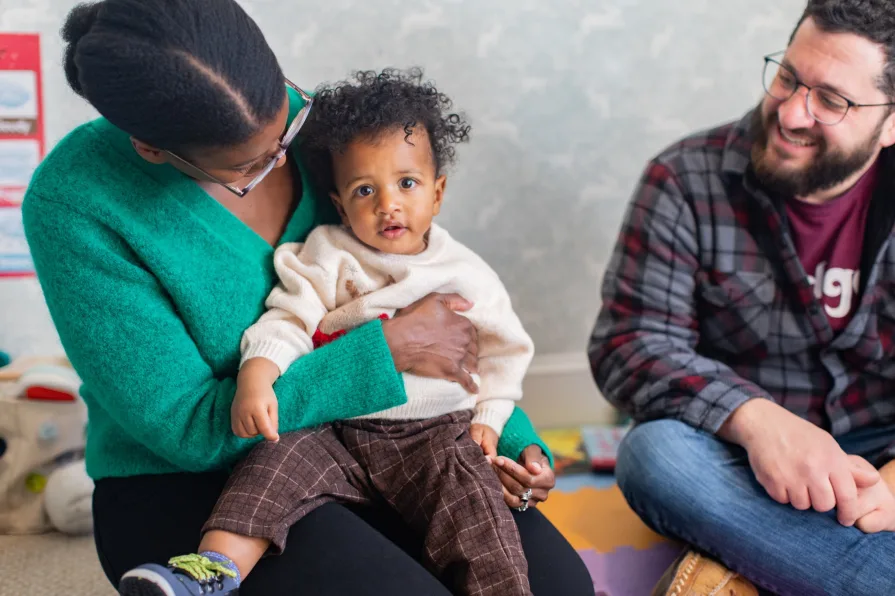 An interracial couple with their one-year-old during a family photo session.