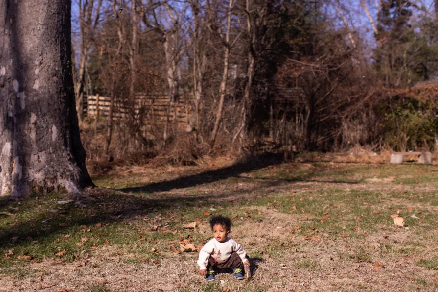 One-year-old Forest crouches in the grass in his backyard in the Philadelphia suburbs.