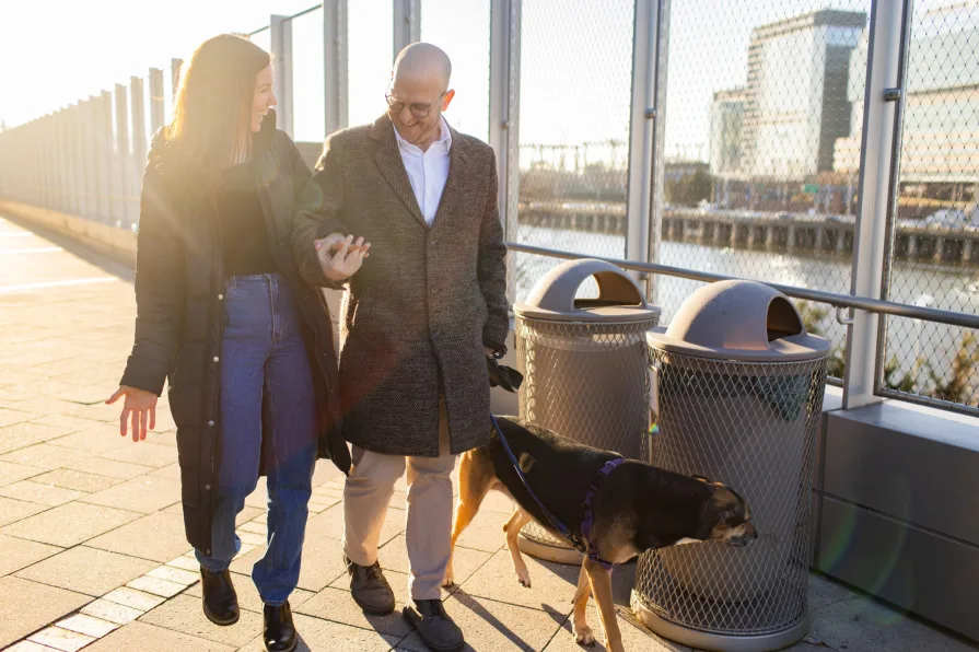 A couple walking with their dog after getting engaged in Philadelphia.
