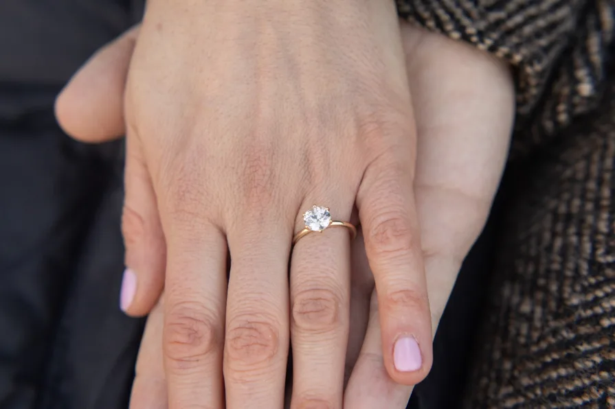 A detail of an engagement ring on a woman's hand after their proposal.