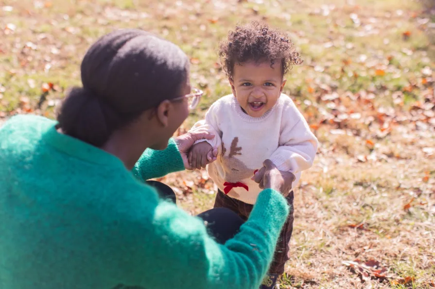 A mother plays with her child in their backyard.
