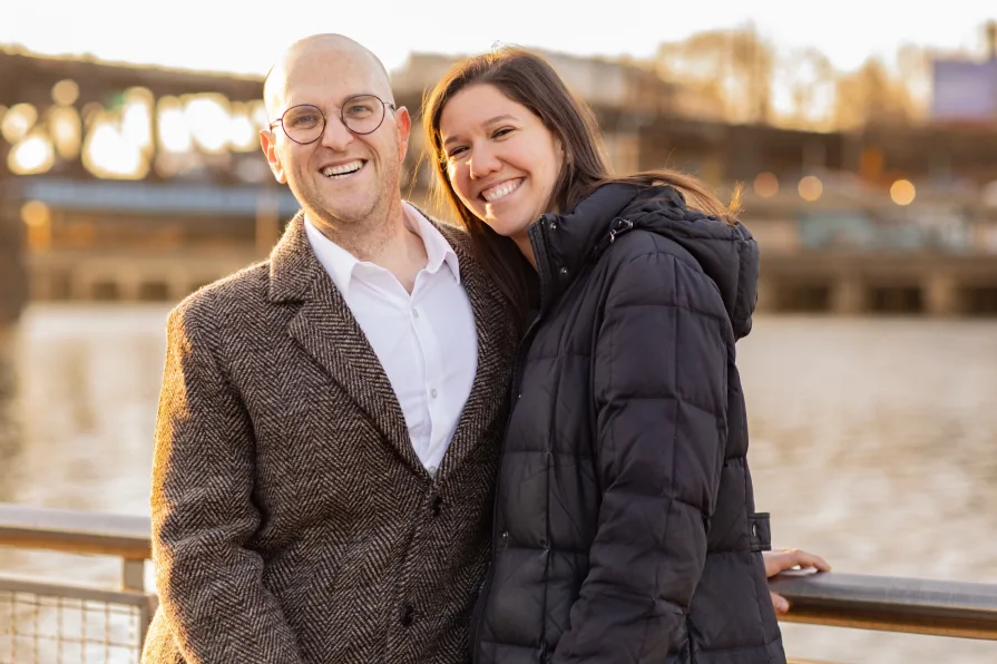 A couple walking with their dog near Schuylkill River Trail after getting engaged in Philadelphia.