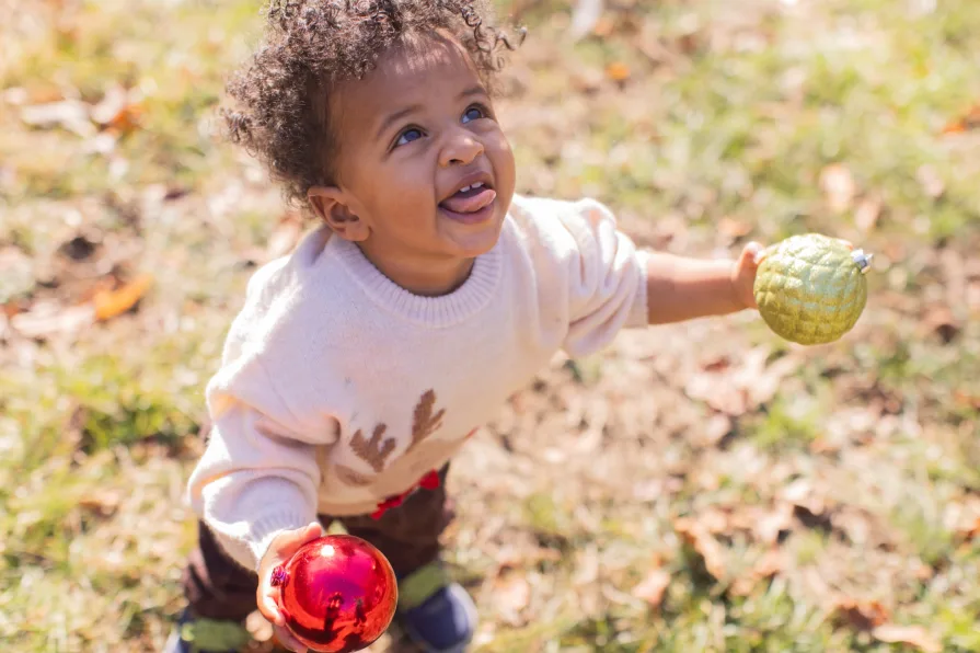 Forest looks up while smiling with a Christmas ornament.