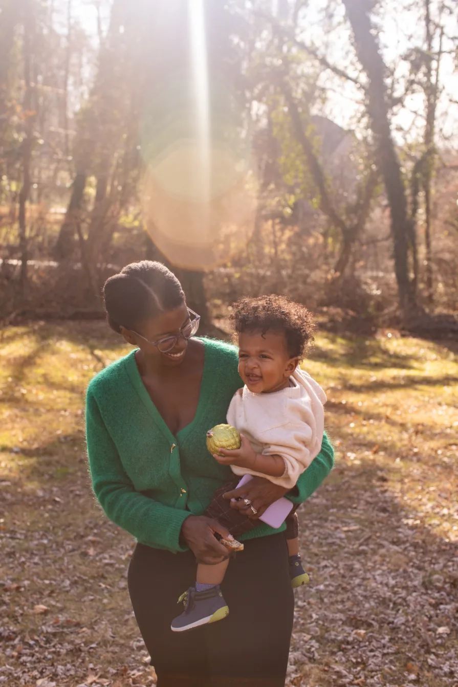 One-year-old Forest is held by his mom in their backyard during a family photo session.