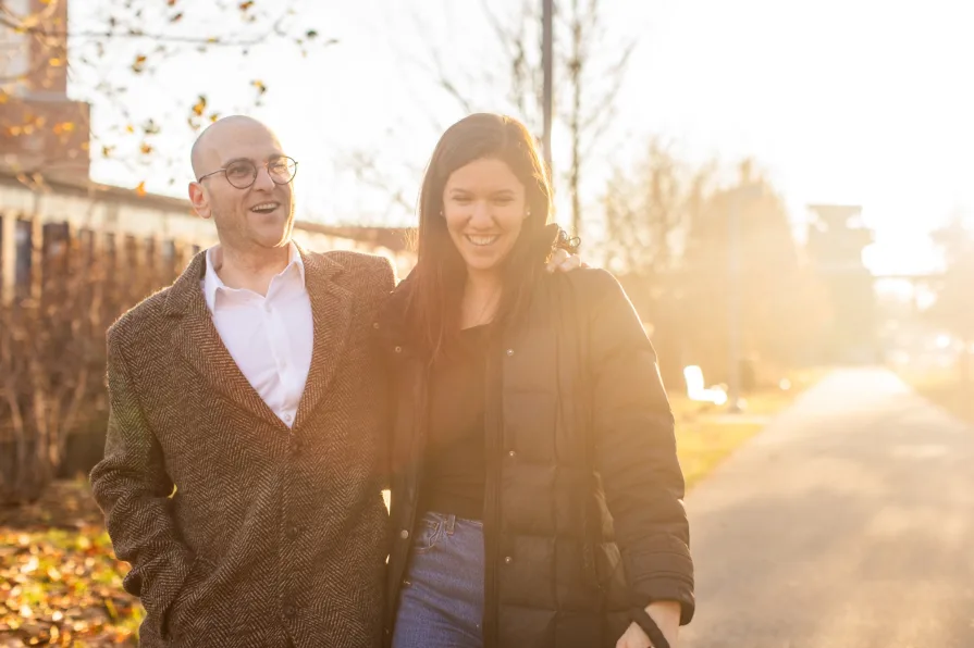 A couple walking with their dog near Schuylkill River Trail after getting engaged in Philadelphia.