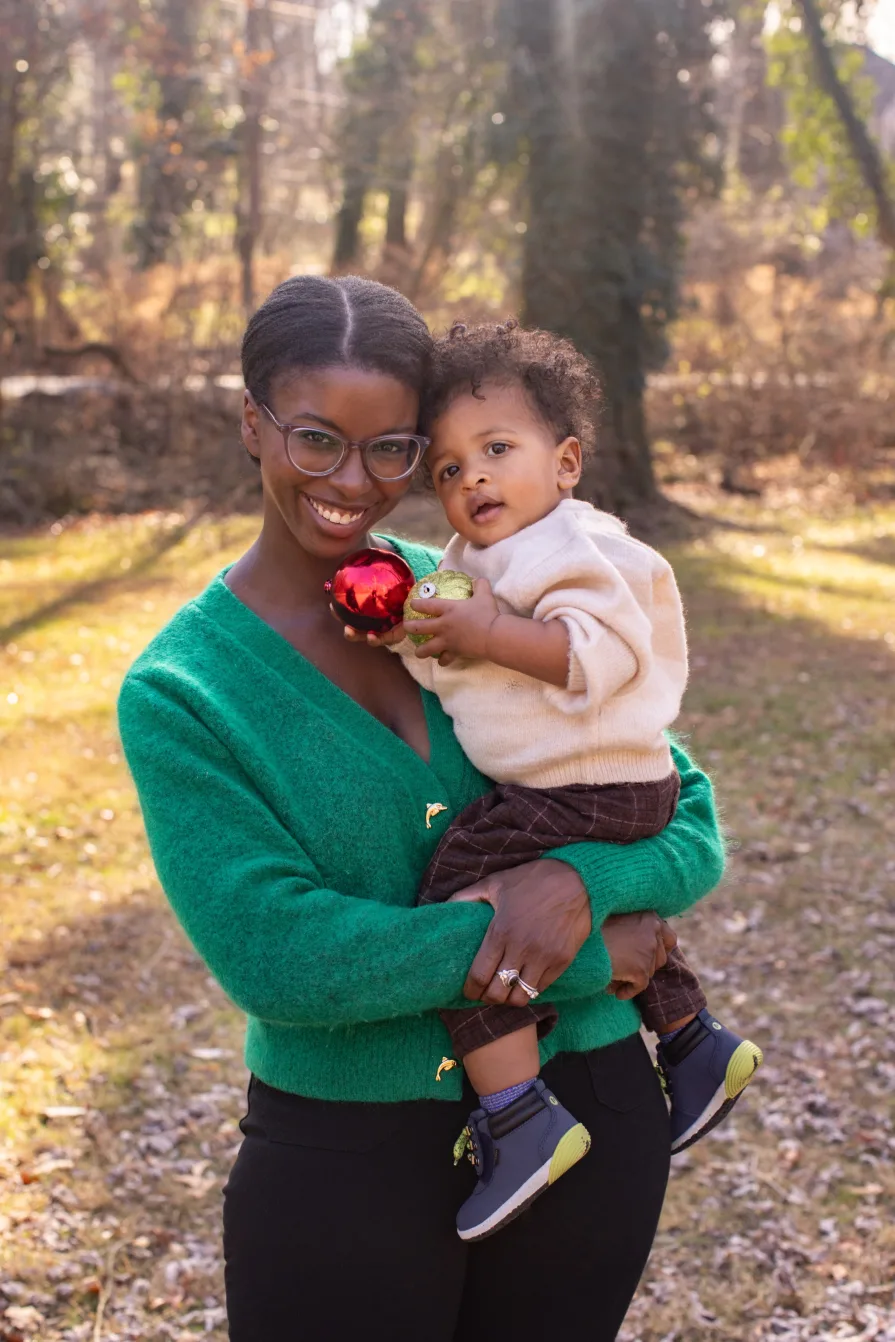 One-year-old Forest is held by his mom in their backyard during a family photo session.