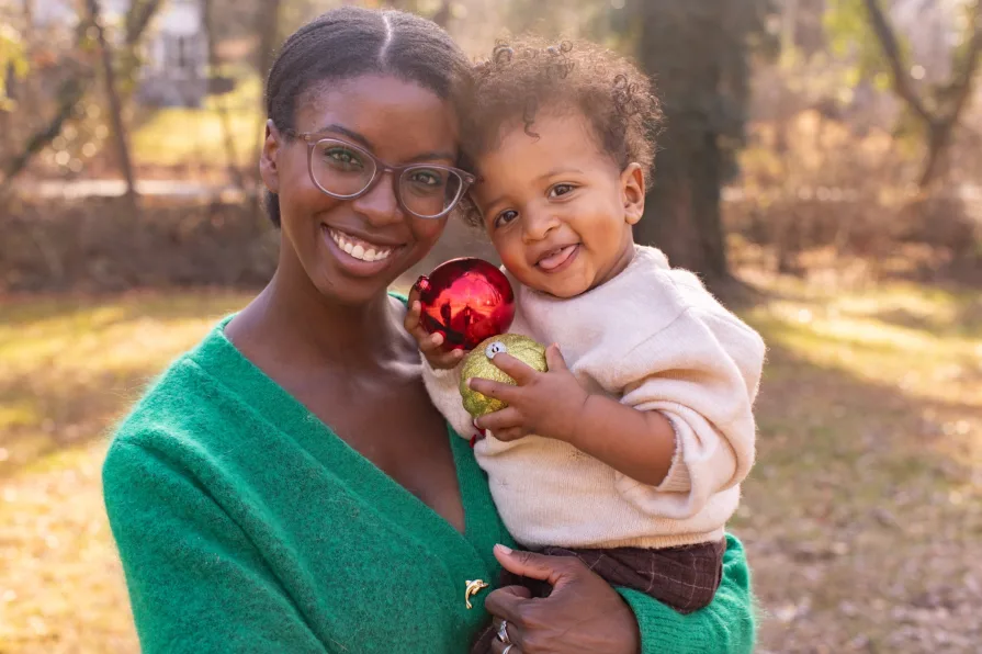 One-year-old Forest is held by his mom in their backyard during a family photo session.