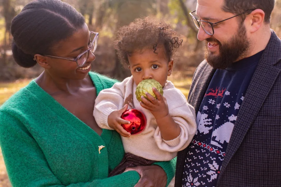 An interracial family of three in their backyard during a family photo session.