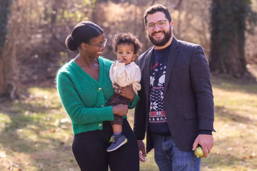 An interracial family of three in their backyard during a family photo session.