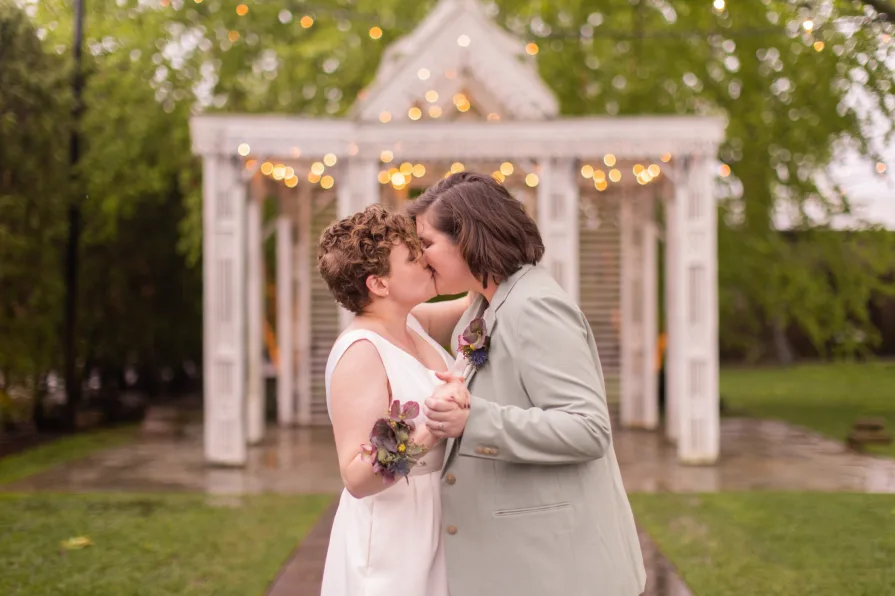 Queer marriers dance outside in the rain at Terrain at Styer's in Glen Mills for their wedding photos.