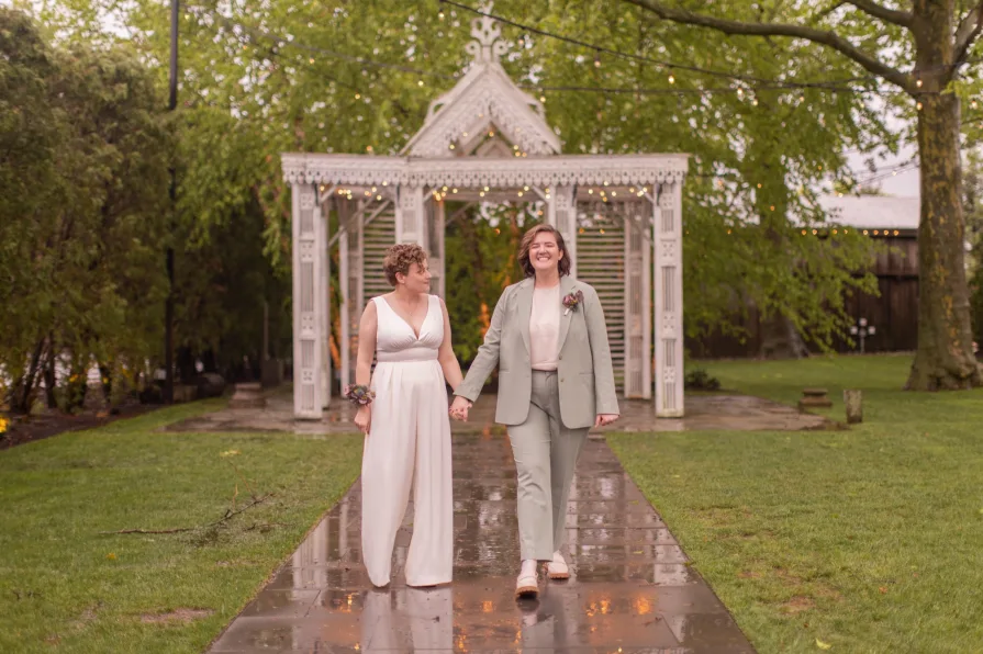 Queer marriers dance outside in the rain at Terrain at Styer's in Glen Mills for their wedding photos.