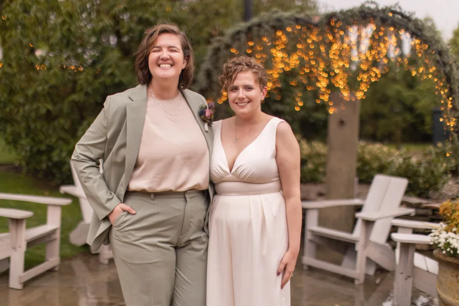 Queer marriers dance outside in the rain at Terrain at Styer's in Glen Mills for their wedding photos.