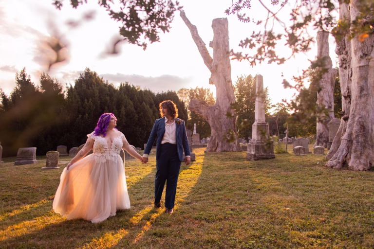 A couple on their wedding day at The Woodlands cemetery with cut trees.